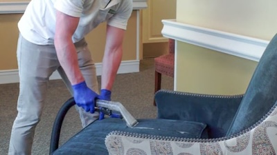 Flexgreen technician cleaning an upholstered chair at a senior living facility to represent the Flexgreen upholstery cleaning service offered to commercial properties in the Carolinas and Virginia