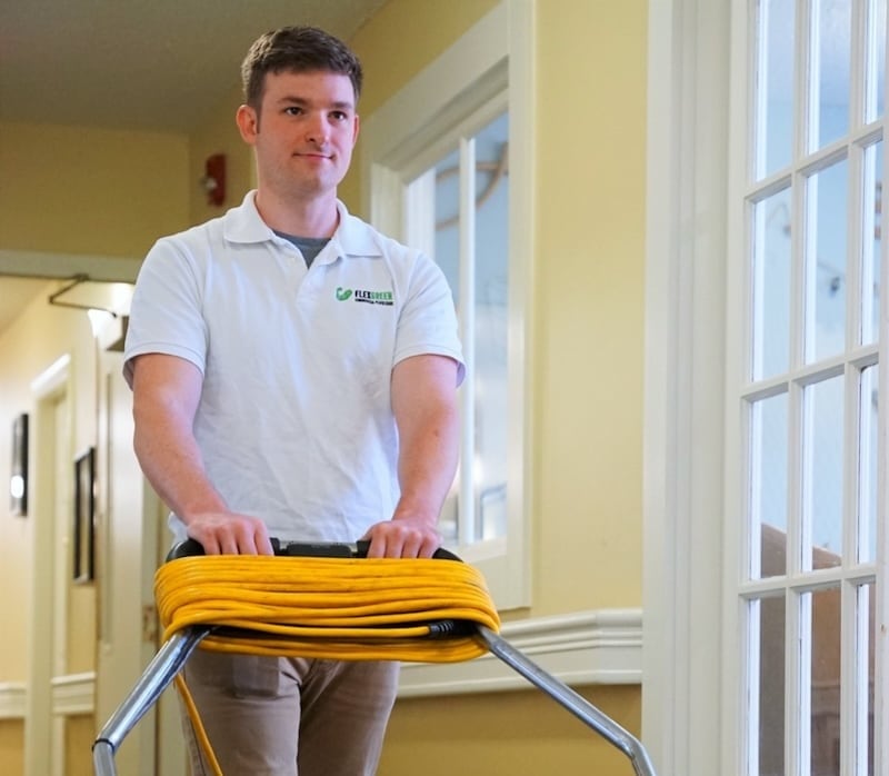 A Durham local employee running a commercial vacuum at a senior living facility