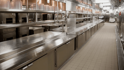 An empty commercial kitchen with tile floors to represent Flexgreen's tile and grout degreasing floor care service