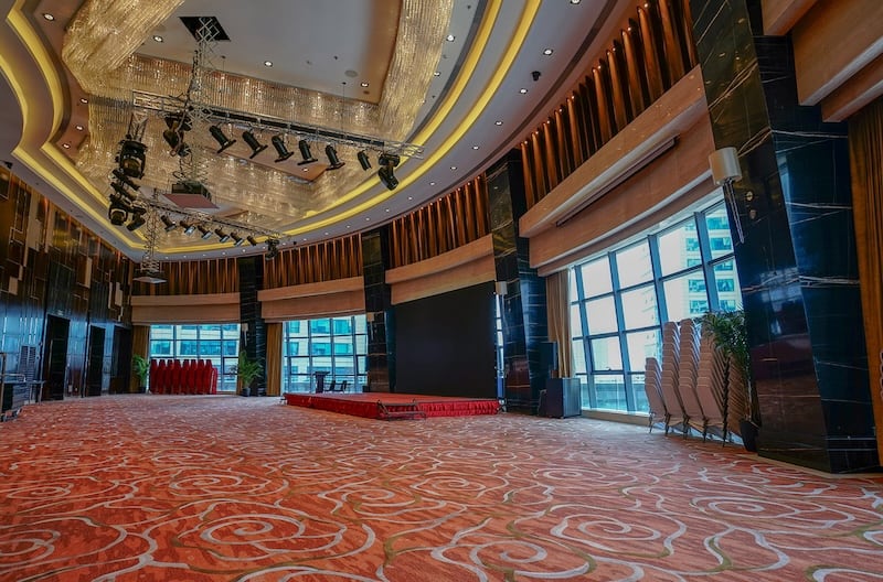 An empty multi purpose event room with carpeted flooring that is a focal point in the room